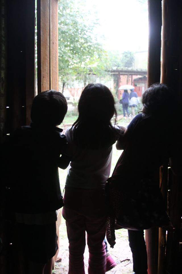 3 crianças debaixo da porta observando o exterior